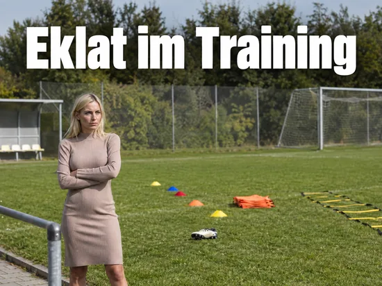 Trainingsplatz mit Hütchen und Trainingsleiter, ein einzelner Fussballschuh liegt im Gras, eine Frau steht am Rand