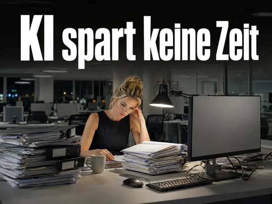 Frau im Büro mit hohen Aktenstapeln vor einem leeren Bildschirm
