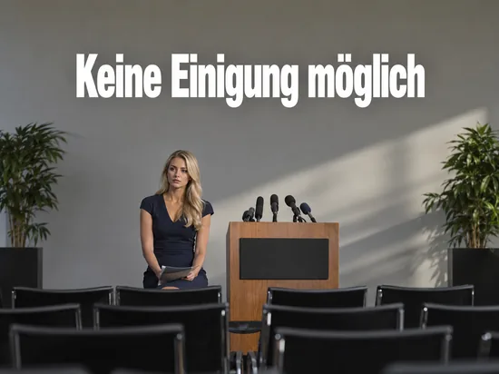 Frau sitzt neben einem Rednerpult mit Mikrofonen vor leeren Stuhlreihen