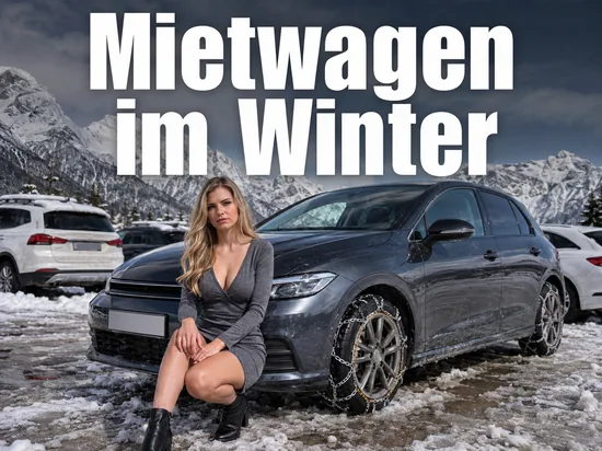 Auto mit Schneeketten auf einem verschneiten Parkplatz vor einer Bergkulisse