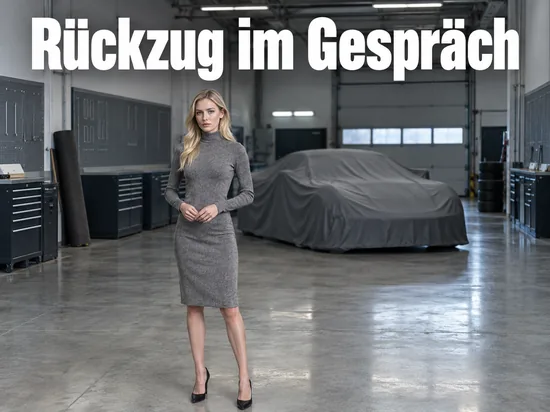 Leere Rennsport-Werkstatt mit einem abgedeckten Fahrzeug, eine Frau steht in der Halle