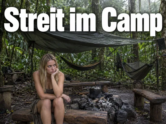 Frau sitzt an einer erloschenen Feuerstelle in einem Camp im Regenwald