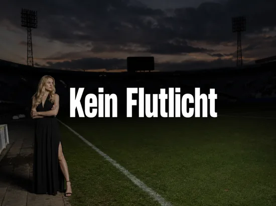 Grosses Fussballstadion am Abend mit dunklen Flutlichtmasten und Anzeigetafel, davor eine Frau mit enttaeuschtem Blick