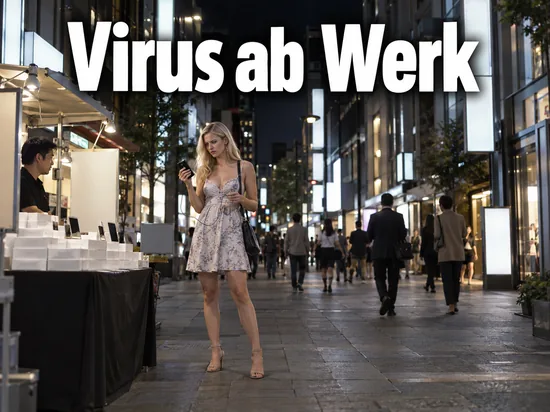 Frau prüft auf einer abendlichen Einkaufsstraße einen kleinen MP3-Player neben einem Verkaufsstand