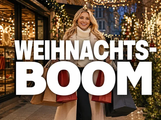 Weihnachtsgeschäft als Traumsituation für den Einzelhandel, gut gelaunte Geschäftsfrau mit vielen Einkaufstüten in festlicher Einkaufsstraße
